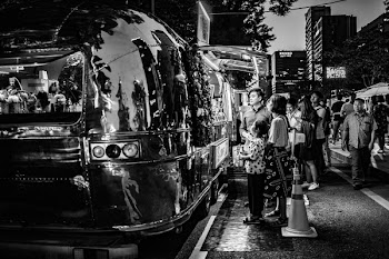 Grayscale Photography of People in Line of Airstream Trailer