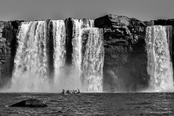 Grayscale Photography Of People Riding A Boat Near Waterfalls
