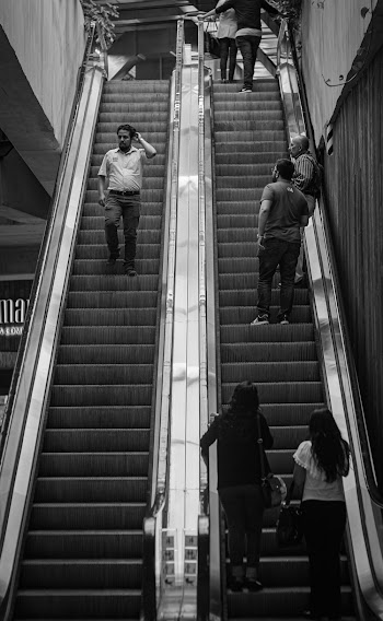 Grayscale Photography of People Riding Escalators