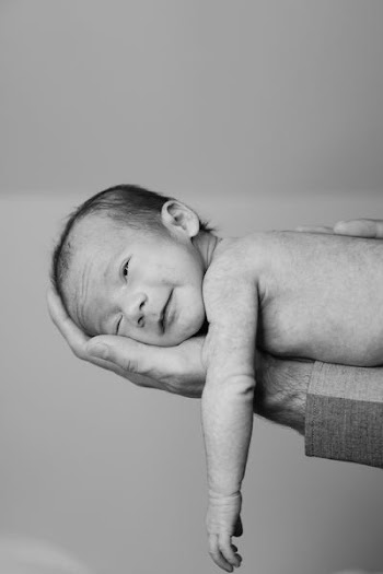 grayscale photography of person holding holding baby