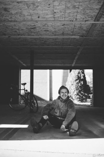 grayscale photography of person sitting ground near bike