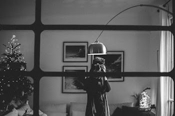 Grayscale Photography of Person Taking Photo Under the Floor Lamp