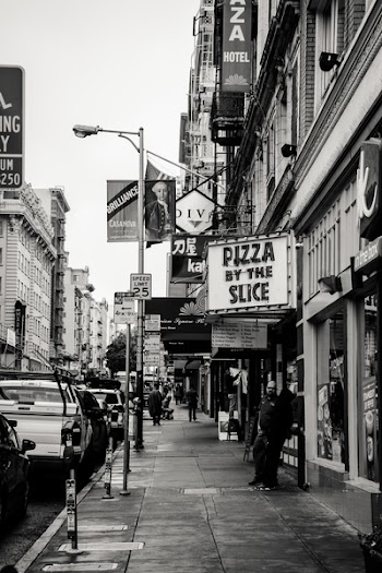 Grayscale Photography of Pizza by the Slice Signage