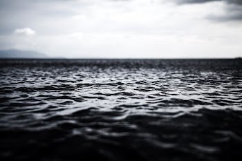 grayscale photography of rippling body of water