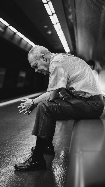 Grayscale Photography Of Sitting Man 