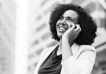 Grayscale Photography of Smiling Woman Using Smartphone