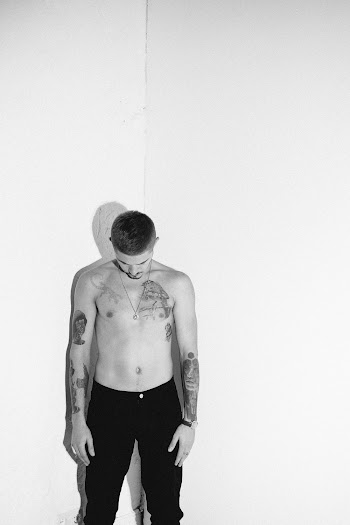 Grayscale Photography of Topless Man Standing While looking Down