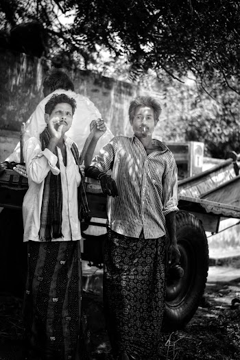 Grayscale Photography of Two Men Standing Under Tree Smoking