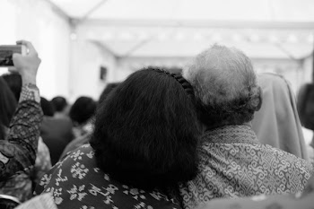 Grayscale Photography of Two Person Resting Their Head on Each Other