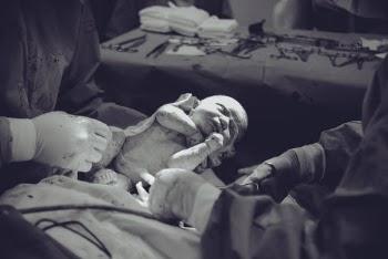 Grayscale Photography of Unknown Person Carrying Newborn Baby