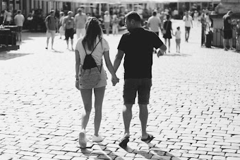 Grayscale Photography of Woman and Man Holding Hands While Walker