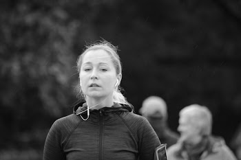 Grayscale Photography of Woman in Zip-up Jacket and Wearing White Earbuds