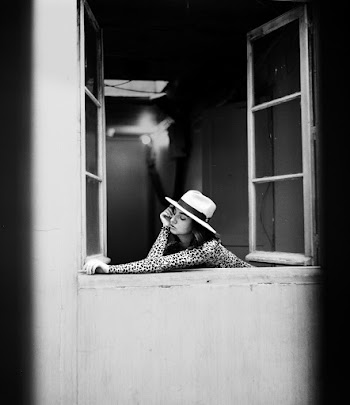 Grayscale Photography Of Woman Leaning On Open Window