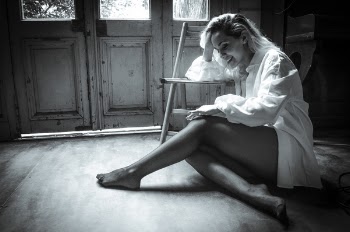 Grayscale Photography of Woman Resting Head Sitting Down