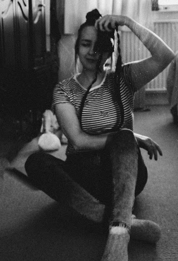 Grayscale Photography of Woman Sitting and Holding Camera