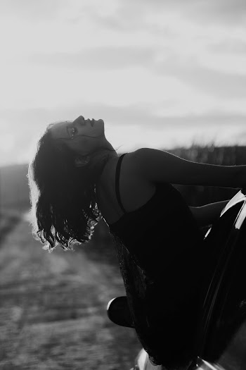 Grayscale Photography of Woman Sitting in Car Window