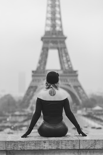 Grayscale Photography of Woman Sitting on Bench Watching View of Eiffel Tower