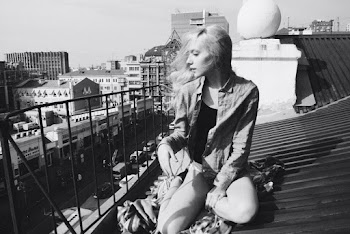 Grayscale Photography of Woman Sitting on Rooftop