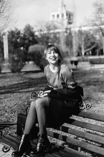 Grayscale Photography of Woman Sitting on Slatted Bench