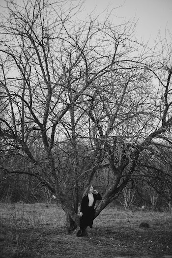 Grayscale Photography of Woman Standing and Leaning on Bare Tree