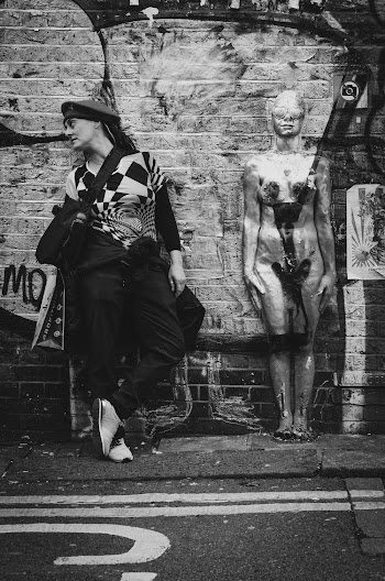 Grayscale Photography Of Woman Standing Beside Human Figure While Looking To Her Right