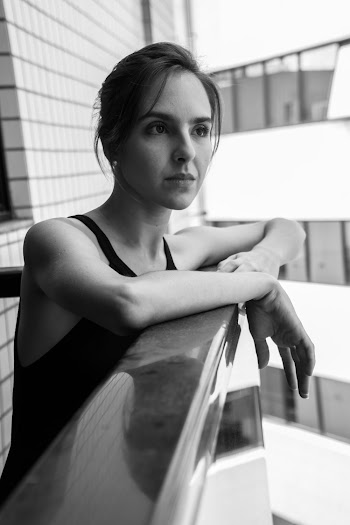 Grayscale Photography of Woman Standing Near Building