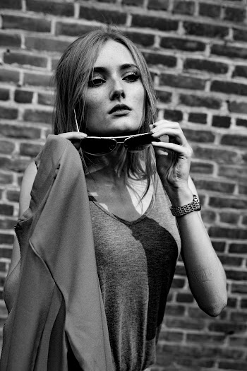 Grayscale Photography of Woman Standing Near Wall