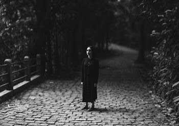 Grayscale Photography of Woman Standing on Brick Road