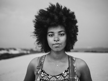 grayscale photography of woman standing on wide field