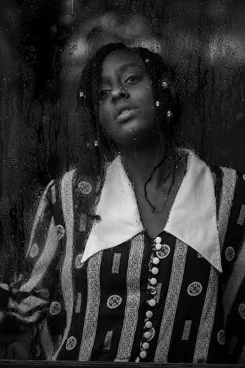 Grayscale Photography of Woman Standing Through the Window