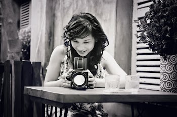 Grayscale Photography of Woman Using Camera While Sitting