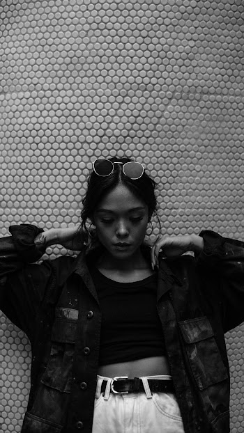Grayscale Photography of Woman Wearing Jacket Standing While Looking Down