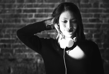 Grayscale Photography of Woman Wearing Long-sleeved Top and Headphones in Front of Wall