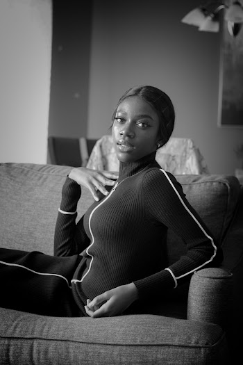 Grayscale Photography of Woman Wearing Zip-up Jacket Sitting on Couch