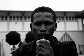 Grayscale Portrait Photo of a Man Holding Plastic Cup Drinking From a Straw 