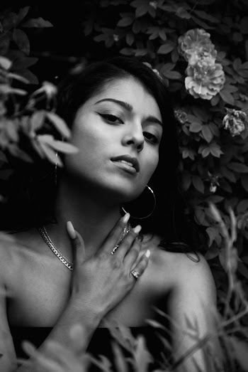Grayscale Portrait Photo of Woman Posing by Flowers 