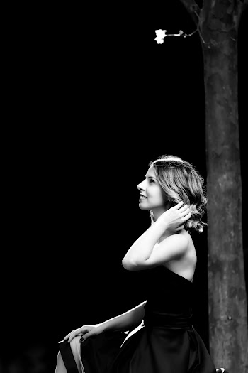 Grayscale Side View Photo of Smiling Woman Looking up Standing Next to Tree