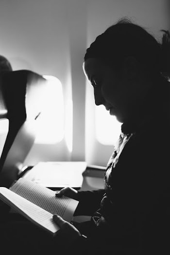 grayscale woman reading book