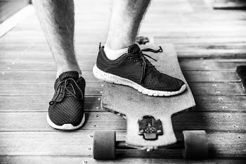 grayscaled photography of person on longboard