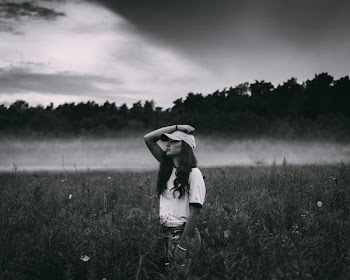 grayscape photo of woman posing in the middle of grass field