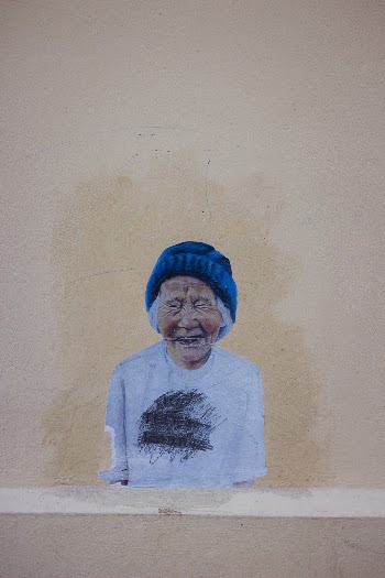 Great expression captured on this older lady's face. She caught my attention when I walked past. Reminds me of the work by street artist  Ernest Zacharevic but I'm not sure it is one of his.