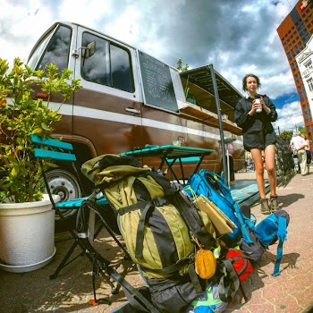 Green and Black Camping Backpack Beside Blue Folding Chair