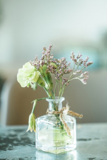 Green and Purple Petaled Flowers in Clear Glass Vase
