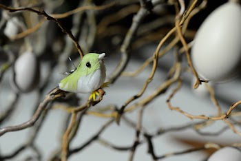 Green and White Bird Toy Perched on Tree Branch at Daytime