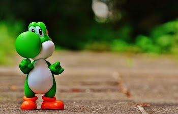 Green and White Dinosaur Toy on Brown Ground in Tilt Shift Photography