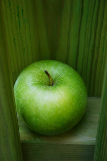 Green apple on green background