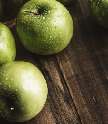 Green Apples on Brown Surface