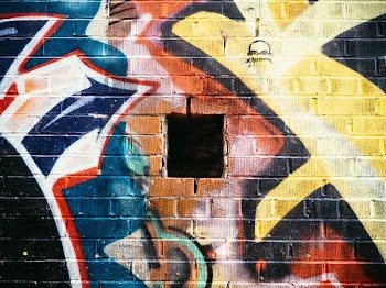 green, brown, and black graffiti artwork on concrete wall