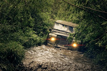 Green Car Running of Flooded Road
