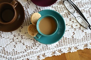 Green Ceramic Cup With Coffee Beside 2 Round Pastry